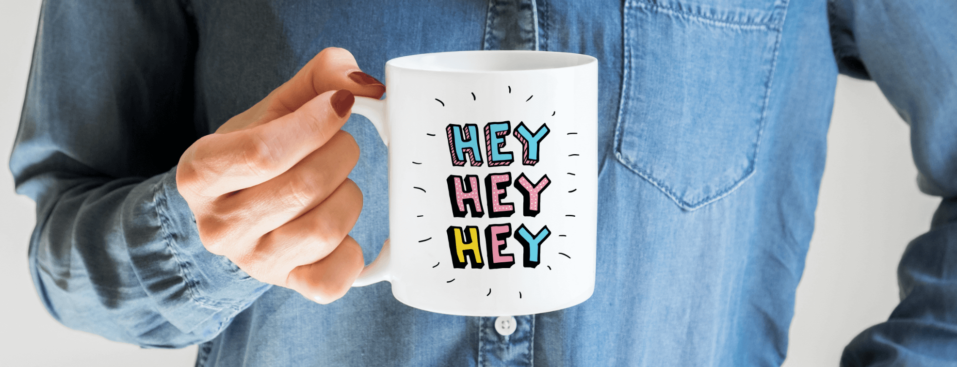 A woman holding a mug with Hey Hey Hey written on it